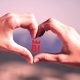 zwei Händen die ein Herz formen, in der Mitte ist das neue Logo von Bielefeld